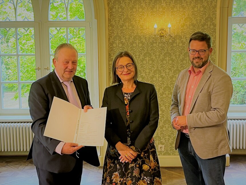 Staatssekretärin Barbara Meyer übergibt dem Bürgermeister der Gemeinde Wachau Veit Künzelmann den Fördermittelbescheid 