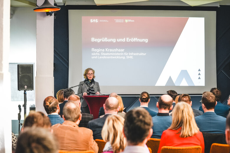 Frau Staatsministerin Kraushaar steht am Rednerpult und eröffnet Fachdialog