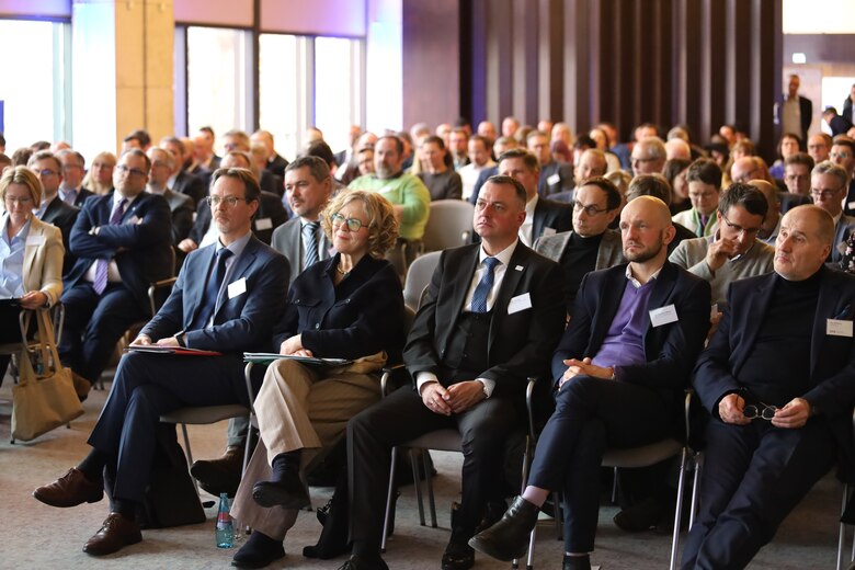 Menschen sitzen auf Stühlen in einer Konferenz